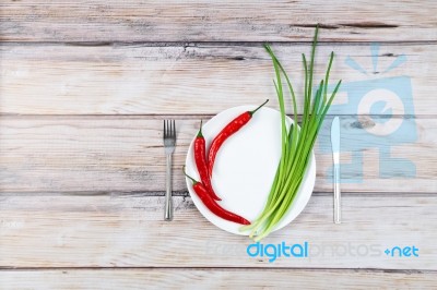 Red Hot Chilli Pepper And Scallions On Plate Stock Photo