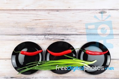 Red Hot Chilli Pepper And Scallions On Plate Stock Photo