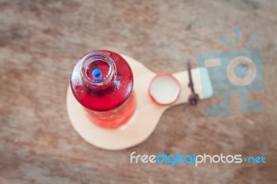 Red Syrup In The Bottle On Wooden Plate Stock Photo