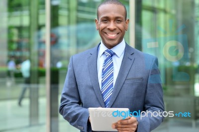 Relaxed Businessman Using His Digital Tablet Stock Photo