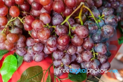 Ripe Red Grape With Leaves On Table Stock Photo