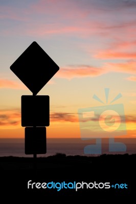 Road Sign Silhouette And Colorful Sunset Stock Photo