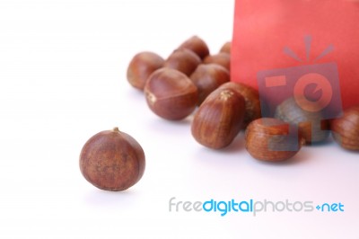 Roasted Chestnuts Outside Red Bag On White Floor Stock Photo