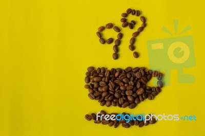 Roasted Coffee Beans Placed In Shape Of A Cup On Yellow Backgro Stock Photo