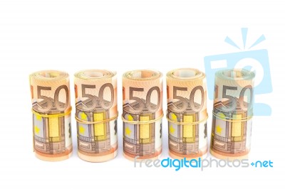 Rolls Of Euro Bills In Row On White Stock Photo