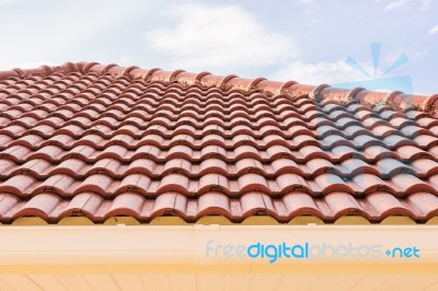 Roof Tiles And Rain Gutter Horizontal View Against Blue Sky Stock Photo
