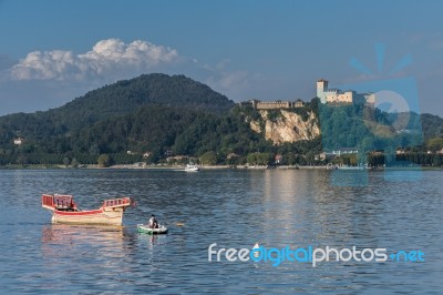 Rowing Boat Pulling A Traditional Boat On Lake Maggiore Piedmont… Stock Photo