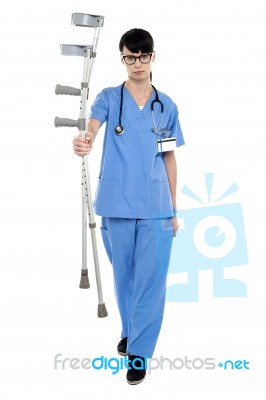 Sad Doctor Holding Up Crutches In Hand Stock Photo