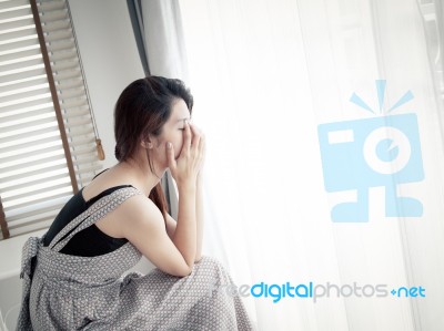 Sad Woman Sitting Alone In Room Stock Photo