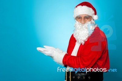 Santa Against Blue Background Posing With Open Palms Stock Photo