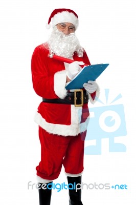 Santa Claus Making List Of Gift Recipients Stock Photo