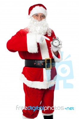 Santa Pointing At An Antique Time Piece Stock Photo
