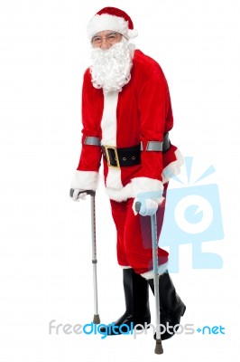 Santa Walking With The Help Of Crutches Stock Photo