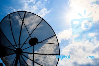 Satellite Dish And Cloudy Sky With Sunbeam Stock Photo