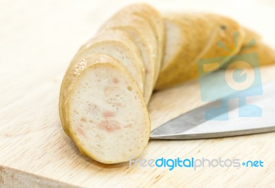 Sausage With Knife Over Cutting Board Stock Photo