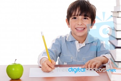 School Boy Doing His Homework With An Apple Beside Him Stock Photo