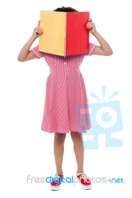 School Girl Hiding Her Face With A Book Stock Photo