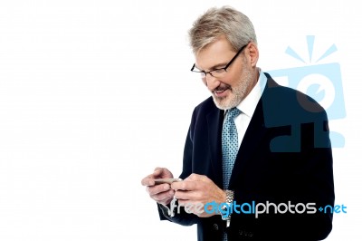 Senior Businessman Reading A Text Message Stock Photo