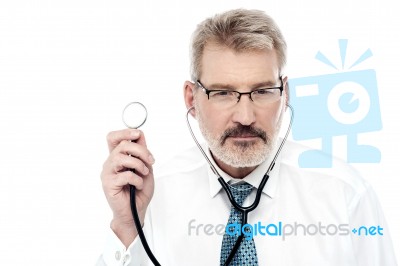 Senior Doctor Holding A Stethoscope Stock Photo