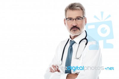 Senior Male Doctor With Crossed Arms Stock Photo