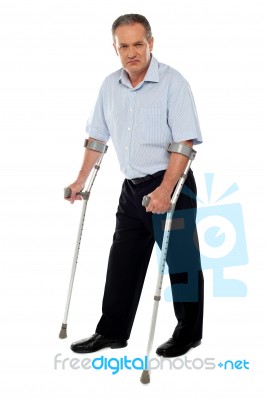 Senior Man Standing With Crutches Stock Photo
