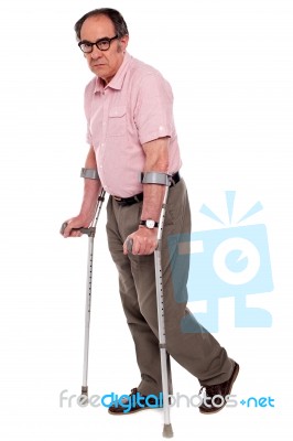 Senior Man walking With Crutches Stock Photo