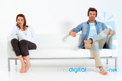 Separated Couple On Sofa Stock Photo