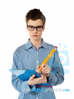 Serious Young Boy Writing On A Clipboard Stock Photo