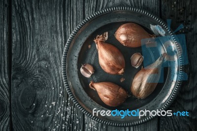Shallot In The Metal Plate On The Wooden Table Top View Stock Photo