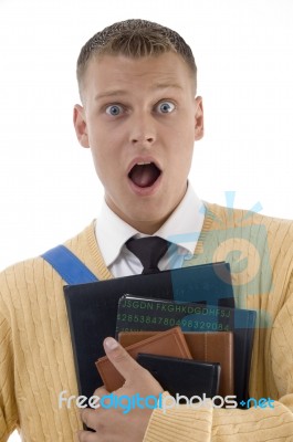 Shocked Male Student Holding Books Stock Photo