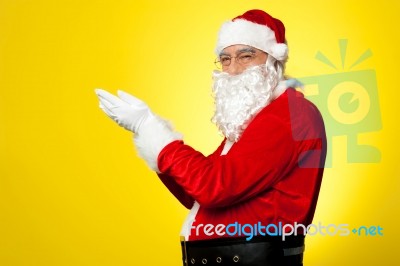 Side Profile Of Santa Facing Camera With Open Palms Stock Photo