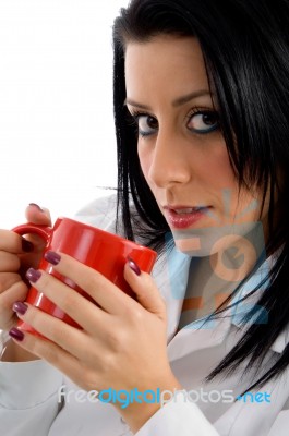 Side View Of Female Doctor Holding Mug On White Background Stock Photo