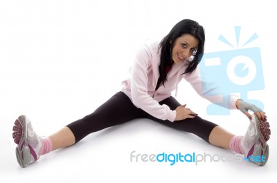 Side View Of Smiling Woman Stretching Her Legs On White Background Stock Photo