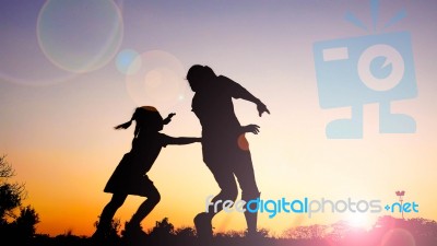 Silhouette Happy Family Mother And Daughter In The Park At Sunset Stock Photo