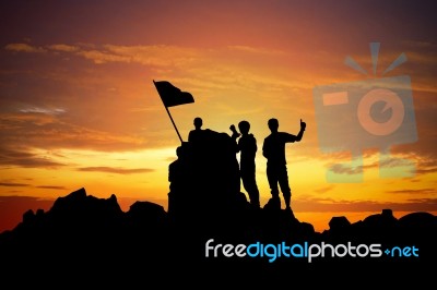 Silhouette Of A Champion On Mountain Peak At Sunset Stock Photo