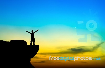 Silhouette Of A Man On The Rock At Sunset Stock Photo