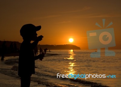 Silhouette Of Child On Sunset Beach Stock Photo
