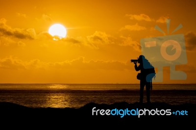 Silhouette Of Photographer With Camera At Sunset Stock Photo