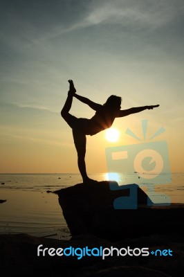 Silhouette Yoga Girl By The Beach At Sunrise Stock Photo