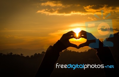 Silhouettes Hand Heart Shaped With Sun Sets Stock Photo
