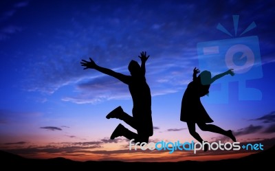 Silhouettes Of Couple Jumping Stock Photo