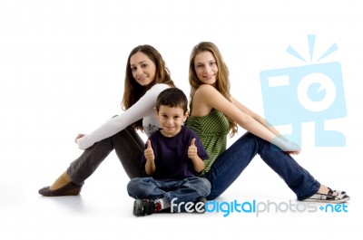 Sitting Siblings And Boy With Thumbs Up Stock Photo