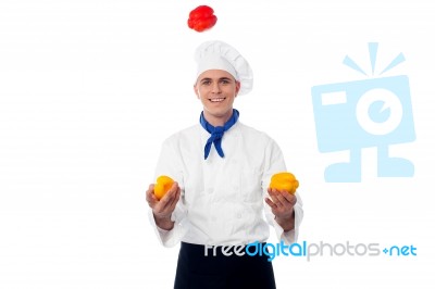 Skilled Chef Juggling With Capsicums Stock Photo