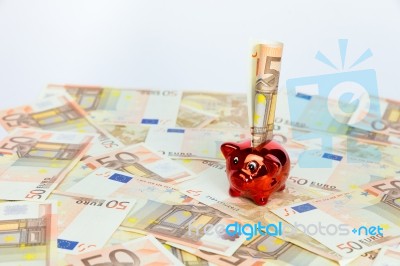 Small Red Piggy Bank On Many Euro Notes Stock Photo