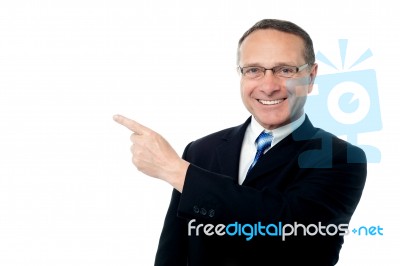 Smart Businessman Pointing Away Stock Photo