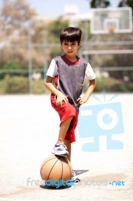 Smart Kid Holding Basketball Under His Leg Stock Photo