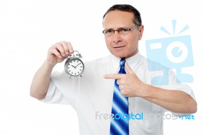 Smiling Businessman Holding An Alarm Clock Stock Photo