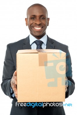 Smiling Businessman Holding Carton Box Stock Photo