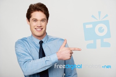 Smiling Businessman Pointing Away Stock Photo