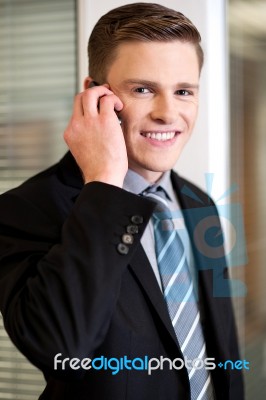 Smiling Corporate Guy Attending Phone Call Stock Photo